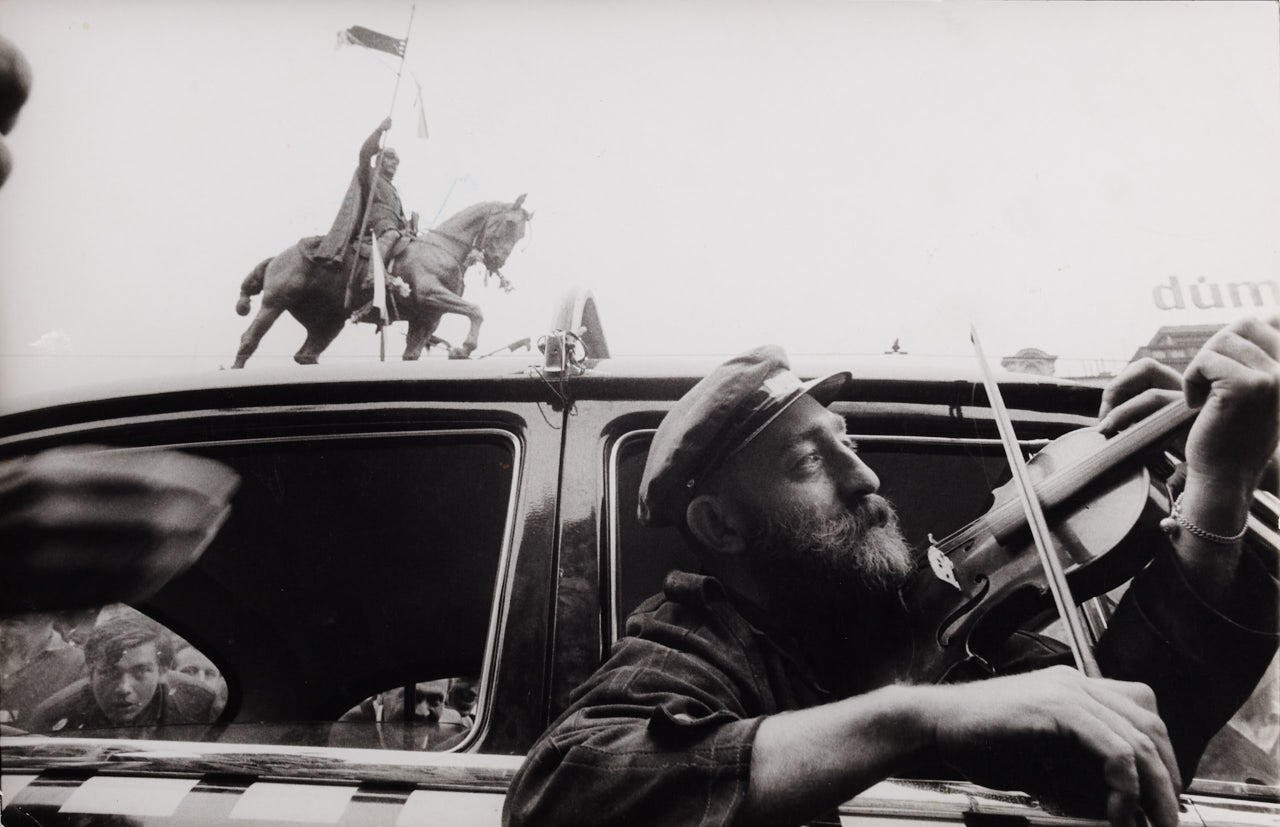 IAN BERRY (* 1934) Prague Spring, A man plays his violin from the car window in Wenceslas Square in defiance of the Russian tanks on the street, 1968