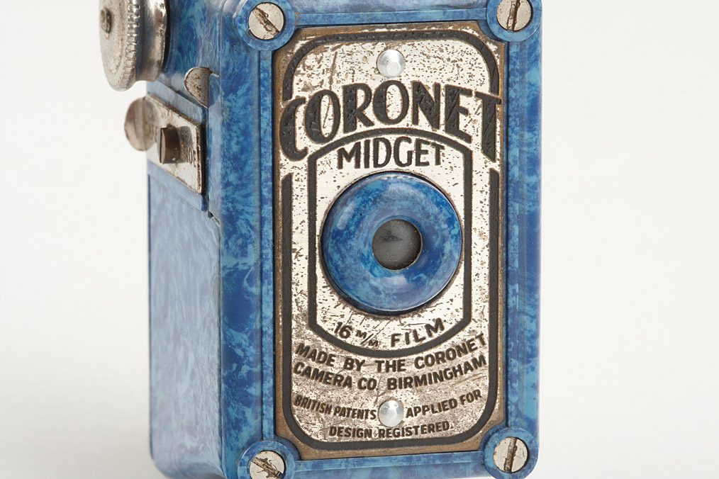A Coronet Midget 16mm film miniature film camera, red mottled Bakelite body, together with a roll of A Coronet Midget 16mm film miniature film camera, red mottled Bakelite body, together with a roll of