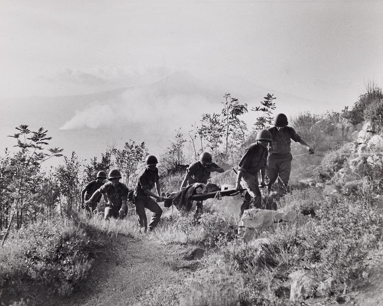 ROBERT CAPA (1913–1954) Along the road to Naples, American troops carrying a wounded near Chiunzi Pass, 1943